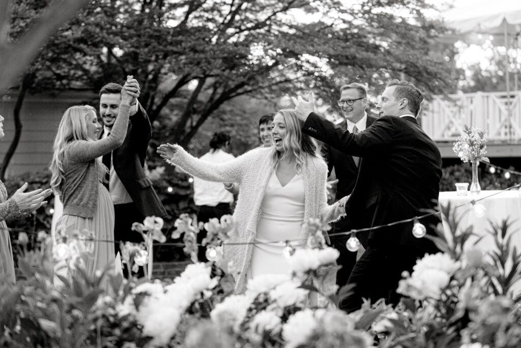 Candid photo of bride and groom and guests dancing in garden at Clifton Inn Charlottesville wedding