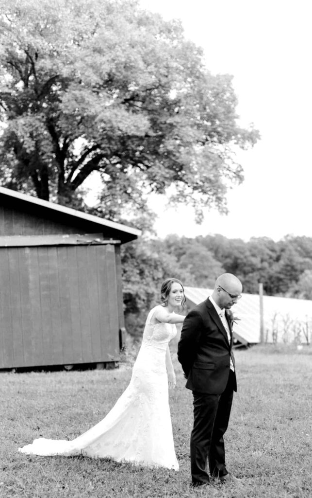 bride tapping groom on shoulder during first look for Charlottesville VA wedding