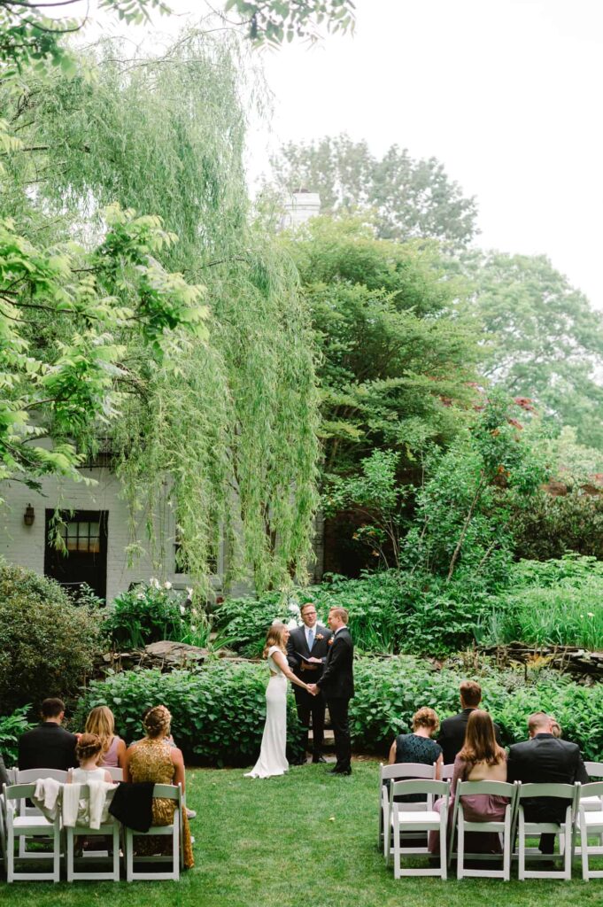 Bride and groom holding hands at altar in Secret Garden of Clifton Inn wedding